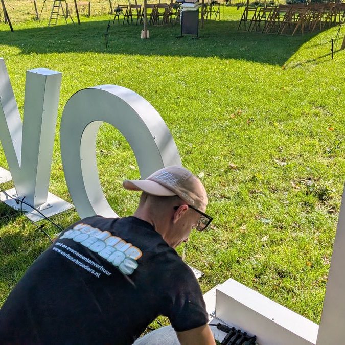 Lichtletters LOVE worden opgebouwd op een grasveld bij een bruiloft buiten