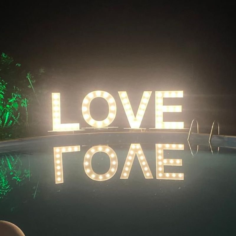 LOVE lichtletters weerspiegeld in een zwembad, avondsfeer